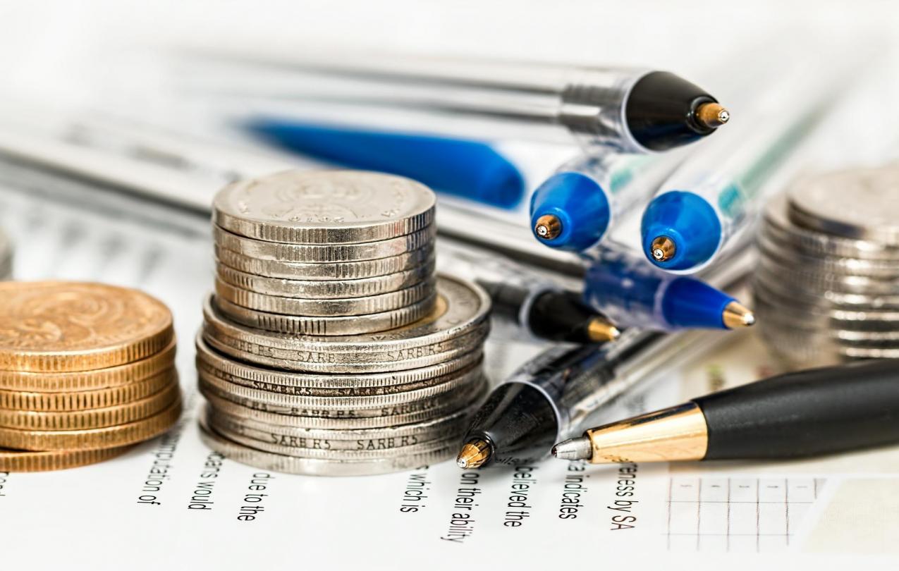 Stacks of coins and pens on a paper form