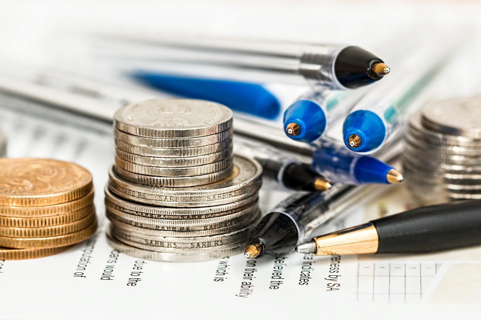 Stacks of coins and pens on a paper form